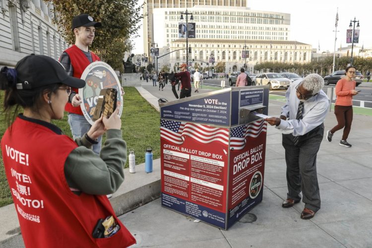 Votantes emiten sus votos en una urna el día de las elecciones fuera del Ayuntamiento de San Francisco, California. EFE/EPA/JOHN G MABANGLO