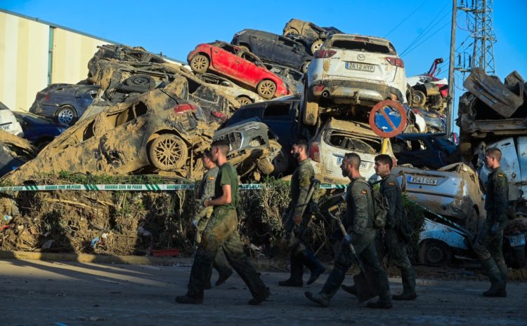 Soldados caminando junto a un cementerio de automóviles tras las mortales inundaciones en Paiporta, cerca de Valencia, este de España, el 27 de noviembre de 2024 Foto: JOSÉ JORDANIA / AFP