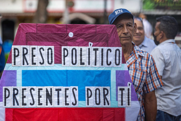 Fotografía de archivo del 8 de agosto de 2024 de un hombre que sostiene un cartel durante una gran vigilia nacional por la liberación de los que consideran presos políticos, convocada por la oposición en la plaza Los Palos Grandes de Caracas (Venezuela). EFE/ Henry Chirinos