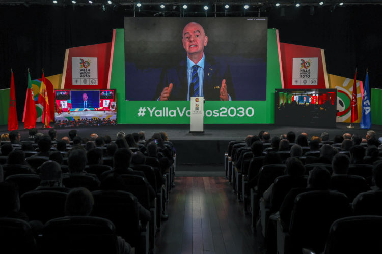 Asistentes al acto observan la intervención del presidente de la FIFA, Gianni Infantino, durante el acto abierto a medios en el que se sigue en directo, con la presencia de diversas autoridades, la reunión del Congreso de FIFA en la que se decide sobre la candidatura conjunta entre Marruecos, Portugal y España - YallaVamos2030 para organizar la Copa del Mundo de fútbol. EFE/ Sergio Pérez