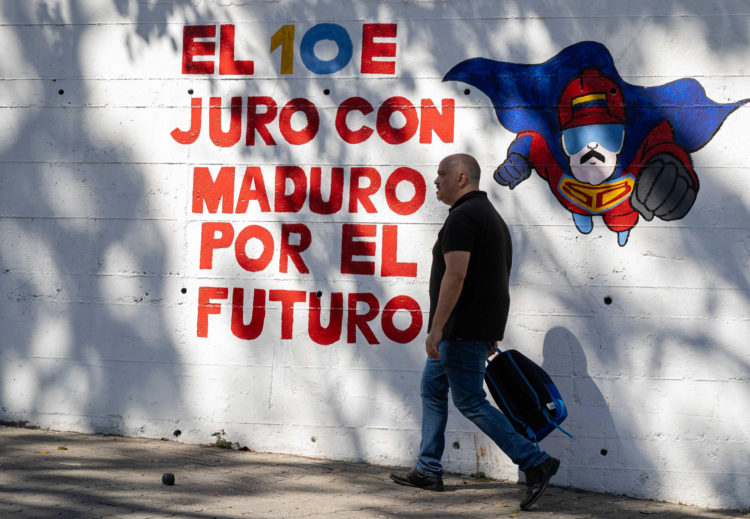 Un hombre camina frente a un mural con el mensaje "El 10E juro con Maduro por el futuro" este viernes, en Caracas (Venezuela). EFE/ Ronald Peña R.