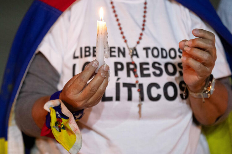 Fotografía de archivo de una mujer con una vela durante una vigilia por los que ellos denominan "presos políticos" en la Universidad Central de Venezuela (UCV). EFE/ Ronald Peña