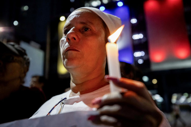 Fotografía del pasado 2 de diciembre de una mujer quesostiene una vela durante una vigilia por la libertad de los "presos políticos" en Caracas (Venezuela). EFE/ Ronald Peña