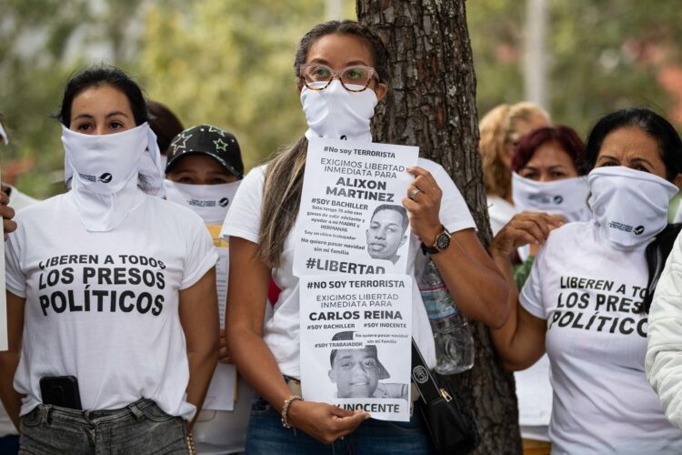 Foto de archivo de una mujer que sostiene dos carteles durante una protesta de Familiares de "presos políticos" frente a la sede del Ministerio Público (Fiscalía), en Caracas (Venezuela). EFE/ Ronald Peña