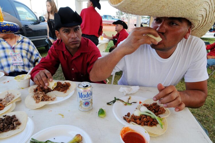 En la imagen de archivo, mexicanos comen tacos durante el festival "Pachangon 5 de Mayo" que se realiza en Orlando, Florida (EE. UU.). EFE/ GERARDO MORA