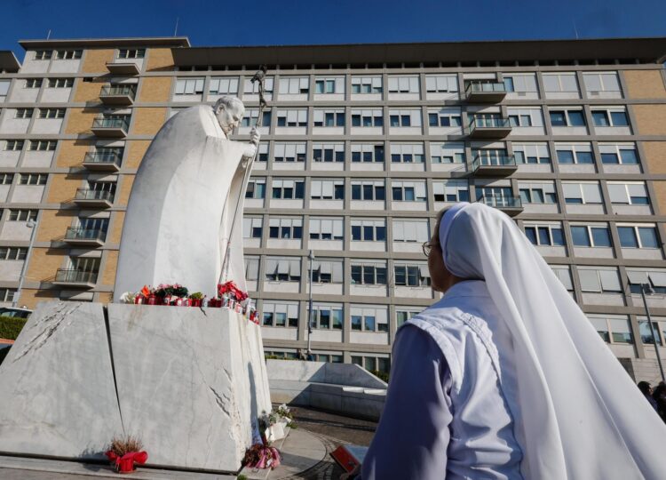 Una monja reza ante una estatua del Papa San Juan Pablo II fuera del Hospital Universitario Gemelli, donde el Papa Francisco está hospitalizado por tratamiento de bronquitis, en Roma, Italia, 21 de febrero de 2025. El Papa Francisco fue hospitalizado el 14 de febrero debido a una infección en las vías respiratorias. (Papa, Italia, Roma) EFE/EPA/GIUSEPPE LAMI