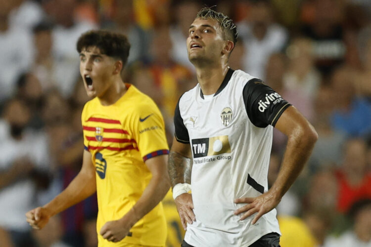 El delantero del Valencia CF Hugo Duro (d) y el defensa del Barcelona Pau Cubarsí tras el primer gol del Barça, durante el partido de la primera jornada de LaLiga que Valencia CF y FC Barcelona disputaron en el estadio de Mestalla, en Valencia. EFE/Biel Aliño