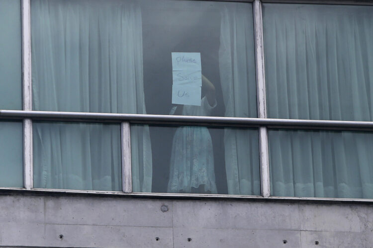 Una persona sostiene un cartel desde una ventana del hotel Decápolis el martes 18 de febrero de 2025 en Ciudad de Panamá (Panamá). EFE/ Carlos Lemos