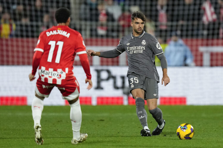 El defensa del Real Madrid Raúl Asencio (d) centra el balón durante el partido de la jornada 19 de LaLiga que Girona FC y Real Madrid disputaron en Montilivi. EFE/ Siu Wu