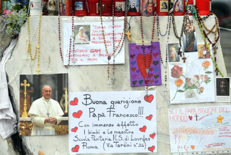 Velas, rosarios y mensajes de apoyo al papa Francisco se exhiben en la estatua del papa Juan Pablo II junto al Hospital Universitario Gemelli, donde está hospitalizado, en Roma, el 8 de marzo de 2025. EFE/EPA/FABIO CIMAGLIA
