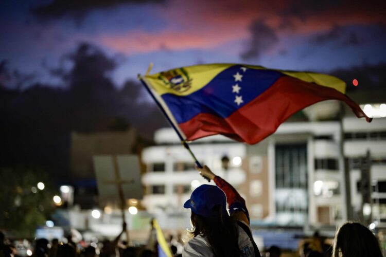 Fotografía de archivo en donde una persona sostiene una bandera de Venezuela. EFE/ Jeffrey Arguedas