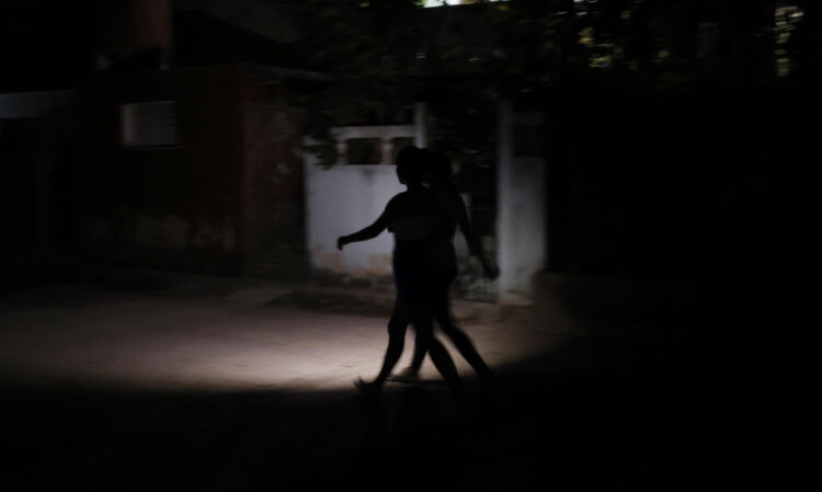 Personas caminan por una calle sin luz este sábado, en La Habana (Cuba). EFE/ Ernesto Mastrascusa