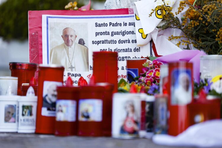 Los fieles dejan velas y tarjetas a los pies de la estatua de Juan Pablo II en la entrada del Hospital Gemelli, donde está hospitalizado el Papa Francisco, en Roma, Italia, 11 de marzo de 2025. EFE/EPA/FABIO FRUSTACI