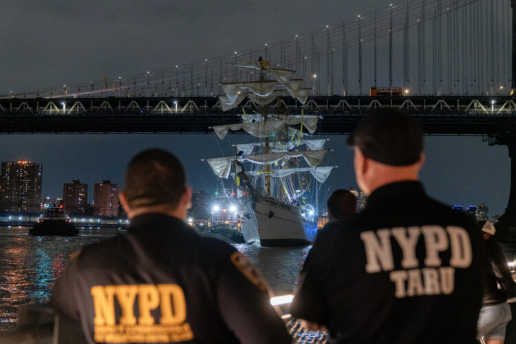 Integrantes del departamento de Policía de Nueva York observan el buque escuela mexicano Cuauhtémoc junto al puente de Brooklyn, el sábado, en Nueva York (EE.UU.). EFE/ Angel Colmenares