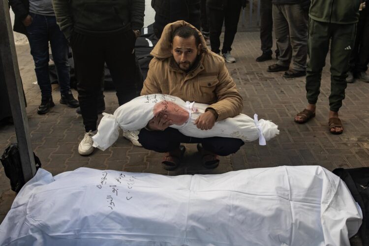 Un hombre sostiene el cuerpo envuelto de una niña mientras los palestinos lloran a sus muertos en el Hospital Al-Najjar tras un ataque aéreo israelí contra el campo de refugiados de Rafah, en el sur de la Franja de Gaza, el 21 de febrero de 2024. EFE/EPA/HAITHAM IMAD