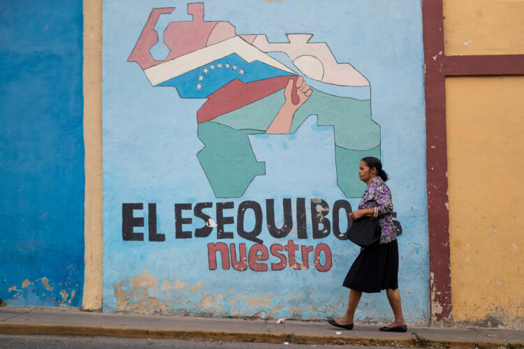 Fotografía de archivo donde se observa a una persona caminar frente a un muro alegórico al territorio del Esequibo, en Caracas (Venezuela). EFE/ Ronald Peña
