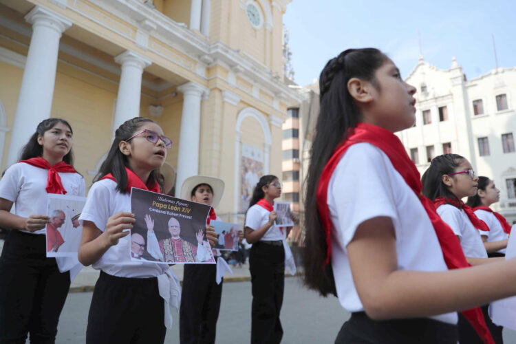 Niños sostienen fotos del papa y cantan canciones este viernes frente a la iglesia Santa María Catedral de Chiclayo (Perú). EFE/Paolo Aguilar
