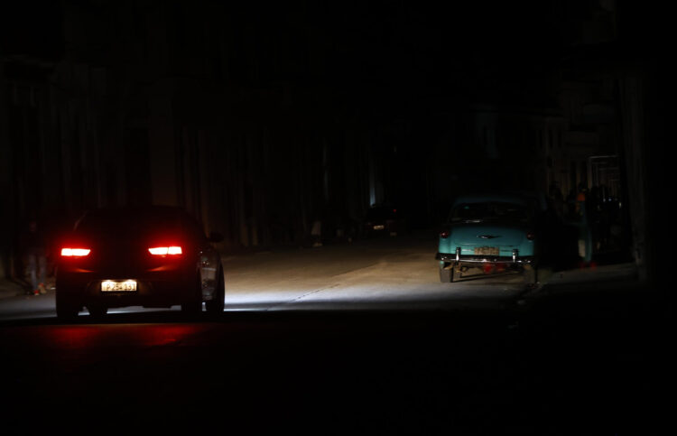 Fotografía de archivo en donde se ve un auto que transita por una calle durante un apagón en Cuba. EFE/ Ernesto Mastrascusa
