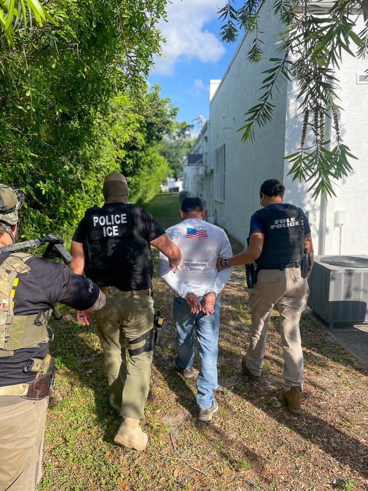 Fotografía divulgada por el Servicio de Control de Inmigración (ICE) donde aparecen uno de sus agentes (i) y un policía de Florida (d) mientras llevan a un indocumentado arrestado en Florida (Estados Unidos). EFE/ ICE