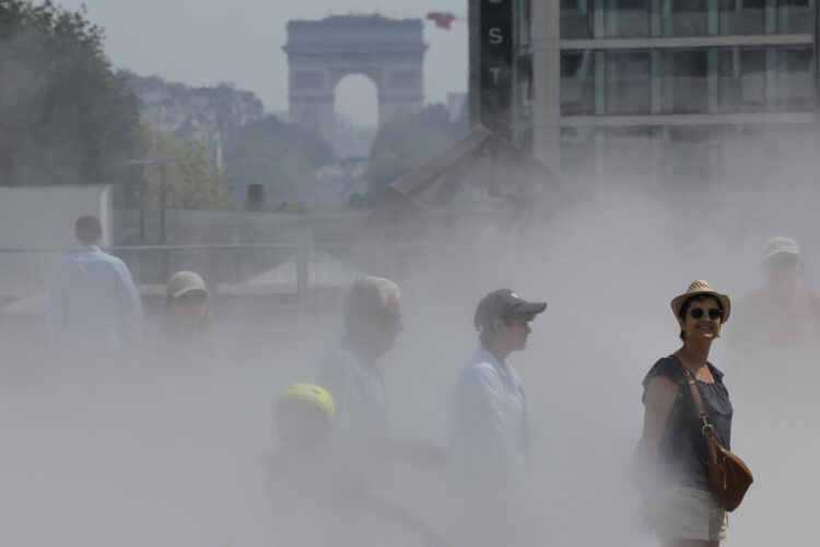Varias personas caminan entre nebulizadores de agua para refrescarse en el centro de París, Francia, en una fotografía de archivo. EFE/ Lavandeira Jr