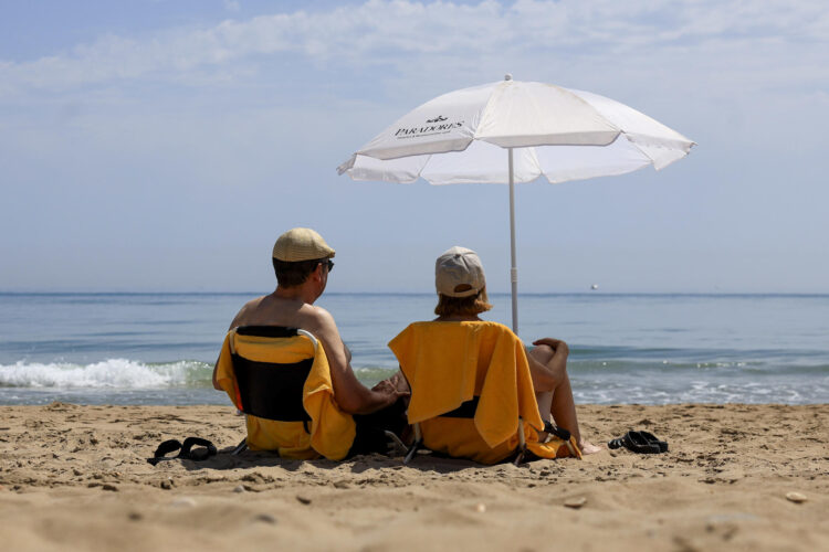 Dos personas disfrutan de un día de playa en El Saller, Valencia, este miércoles. EFE/Kai Forsterling