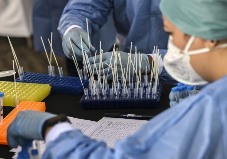 Medical personnel process the PCR tests against the COVID-19 virus taken from participants of the Iran-Venezuela Industrial Scientific and Technological Expoferia prior to the opening ceremony in Caracas, on September 15, 2022. More than 80 Iranian companies are participating in the fair together with some three hundred Venezuelan companies that have requested their participation in the event that takes place from September 15 to 19. (Photo by Yuri CORTEZ / AFP)