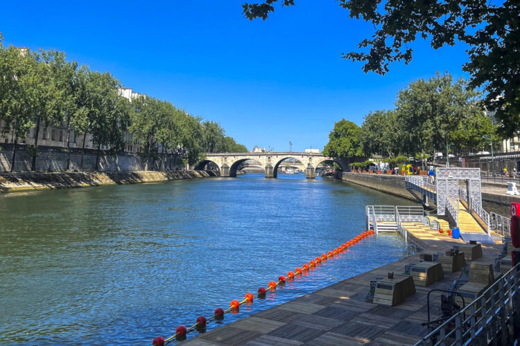 Las plataformas de madera y las boyas naranjas que conforman la nueva zona de baño en el río Sena en Bras Marie frente la Isla Saint-Louis, entre el puente Sully y el puente Marie (al fondo). Este es uno de los tres espacios habilitados para nadar en el Sena que abrirán mañana como herencia de los trabajos de mejora fluvial tras los Juegos Olímpicos 2024.-EFE/ Val Torres