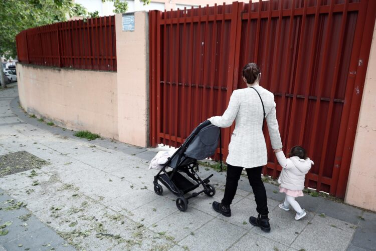 Foto archivo. Una mujer empuja un cochecito de bebé mientras lleva de la mano a su pequeña esta mañana por una calle de Madrid, EFE/ Mariscal