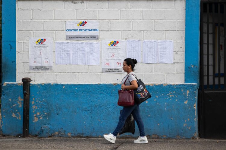 Una mujer camina frente a un centro de votación durante las elecciones municipales y concejales del pasado domingo, en Caracas (Venezuela). EFE/ Ronald Peña R