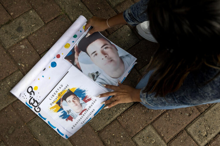 Una persona organiza un cartel en una manifestación en la entrada del Tribunal Supremo de Justicia (TSJ) el martes, en Caracas (Venezuela). EFE/ Miguel Gutiérrez