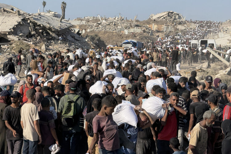 Miles de personas acuden a una zona militarizada cerca del cruce de Zikim, en el norte de la Franja de Gaza, para hacerse con harina del Programa Mundial de Alimentos. EFE/ Ahmad Awad