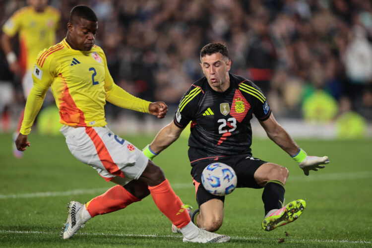 El argentino Emiliano Martínez (d) rechaza un disparo del colombiano Andrés Román, en un partido de las eliminatorias sudamericanas al Mundial 2026. EFE/ Adán González