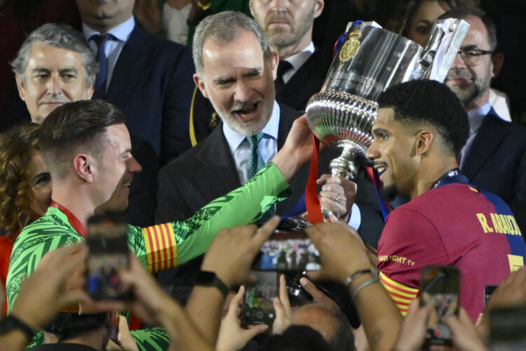 El alemán Marc André ter Stegen (i) y su compañero, el uruguayo Ronald Araujo (d), capitanes del Barcelona, recogen el trofeo de la última Copa del Rey conquistada ante el Real Madrid en el estadio de La Cartuja, en Sevilla. EFE / Raúl Caro.