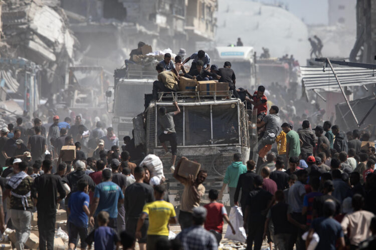 Palestinos alrededor de camiones con ayuda humanitaria. EFE/HAITHAM IMAD