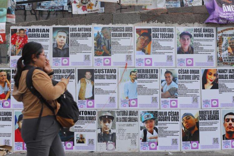 Una mujer pasa frente a carteles de búsqueda de personas este viernes, en la glorieta Niños Héroes, en Guadalajara (México). EFE/ Francisco Guasco