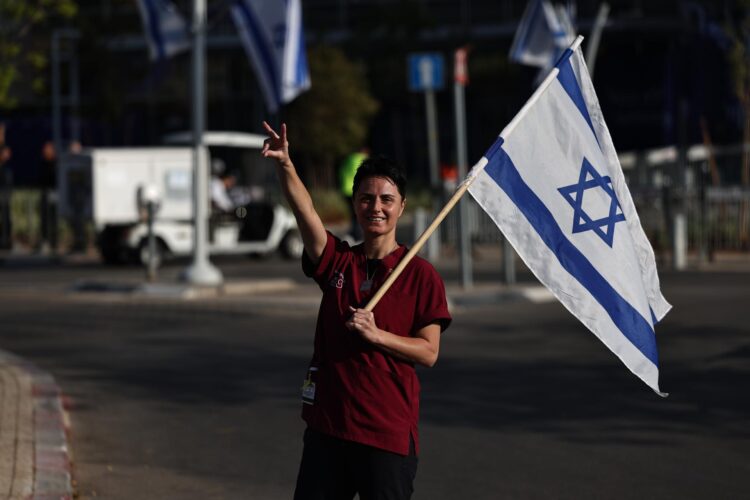 Un trabajador de un hospital israelí agita una bandera y hace gestos antes de la llegada de los rehenes liberados por Hamás en el hospital Shiba en Ramat Gan, cerca de Tel Aviv, Israel, el 13 de octubre de 2025. EFE/EPA/ATEF SAFADI
