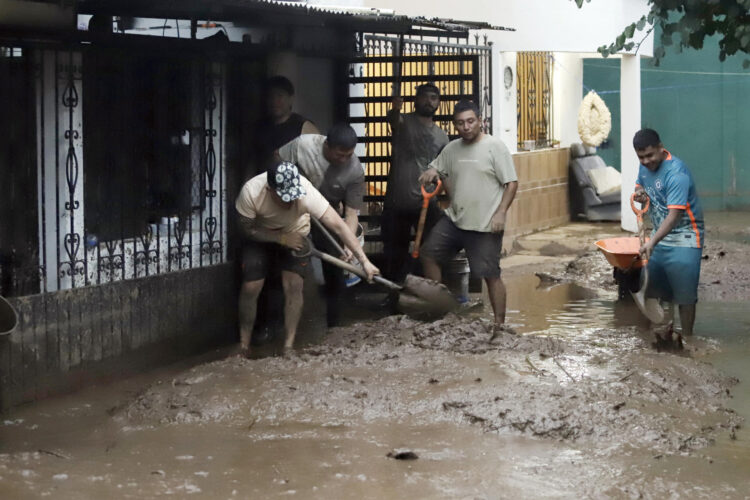 Habitantes de las zonas afectadas por las fuertes lluvias retiran lodo de sus viviendas el domingo 12 de octubre, en Huauchinango (México). EFE/ Hilda Ríos
