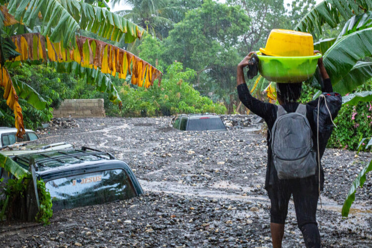 Una persona observa vehículos atrapados por las inundaciones causadas por el paso del huracán Melissa en Petit-Goâve (Haití). EFE/ Mentor David Lorens