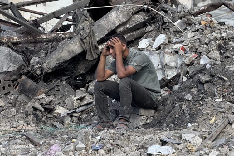 Un gazatí sentado entre los escombros tras un ataque aéreo israelí contra el edificio donde se refugiaban cuatro personas (un padre y sus tres hijas) el 29 de octubre de 2025. EFE/ Ahmad Awad