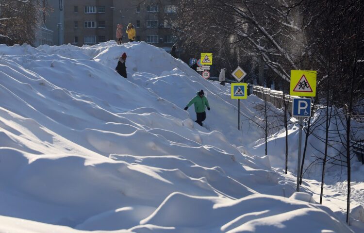 La gente camina sobre un montículo de nieve en el centro de Moscú, Rusia. EFE/EPA/MAXIM SHIPENKOV