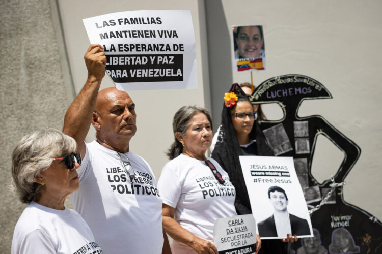 Foto de archivo de personas que sostienen carteles durante una concentración por los presos políticos este lunes, frente a la sede de la embajada de España en Caracas (Venezuela). EFE/ Ronald Pena R