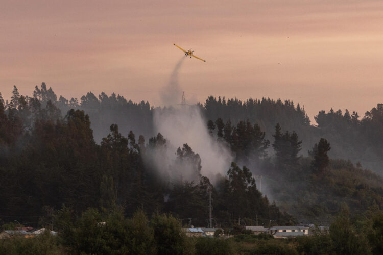 Fotografía que muestra un avión trabajando para controlar un incendio forestal este domingo, en la comuna de Penco, Concepción (Chile). EFE/ Pablo Hidalgo