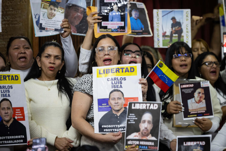 Personas sostienen un carteles en una rueda de prensa este miércoles, en Caracas (Venezuela). Un grupo de familiares pidió que 170 trabajadores de la estatal petrolera Pdvsa, detenidos entre 2024 y 2025, sean incluidos en el proyecto de ley de amnistía que discute el Parlamento -controlado por el chavismo- porque consideran que se trata de un caso político por violaciones al debido proceso, entre ellas, haber sido capturados sin una orden judicial. EFE/ Ronald Peña R