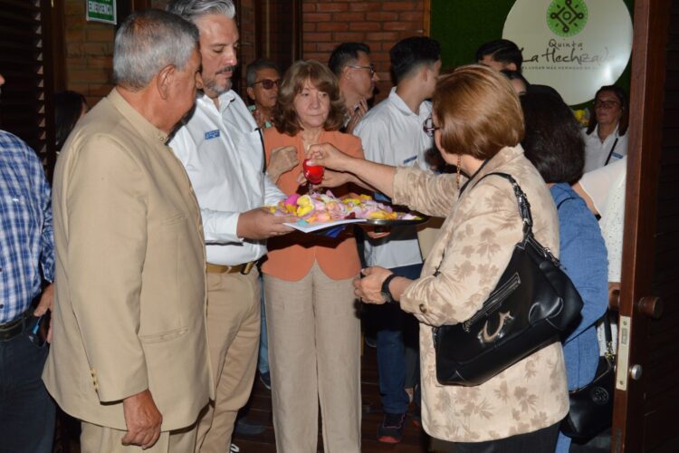 La licenciada Nelly Pineda, procede junto a su familia al bautizo de la obra con el baño de pétalos.