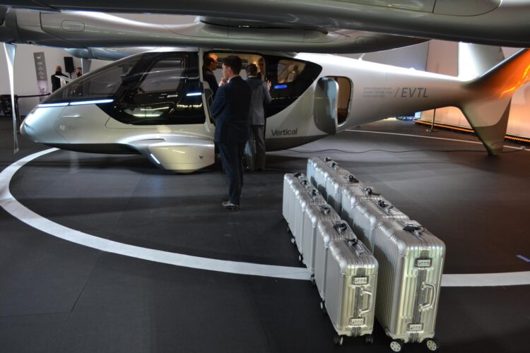 Unas personas preparan las maletas frente a un taxi volador eléctrico de la compañía Vertical Aerospace expuesto el 24 de febrero de 20126 en Miami Beach, Florida. EFE/Antoni Belchi