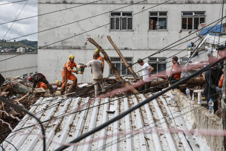 Integrantes del equipo de Bomberos y voluntarios remueven escombros durante las labores de rescate en una zona afectada por fuertes lluvias este miércoles, en Juiz de Fora (Brasil). El número de víctimas mortales causado por las lluvias que azotan el sureste de Brasil aumentó a 36 en el estado de Minas Gerais, mientras que los equipos de rescate buscan a 33 desaparecidos, informaron fuentes oficiales.EFE/ Andre Coelho
