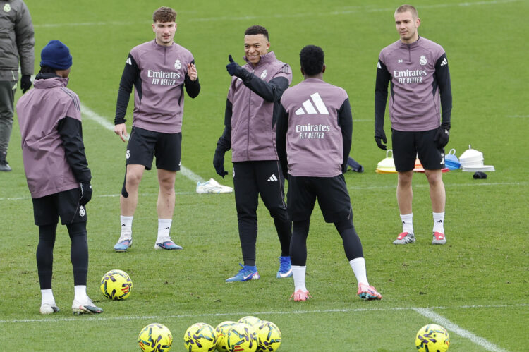 El delantero del Real Madrid Kylian Mbappé (c) asiste al entrenamiento del equipo en la Ciudad Deportiva de Valdebebas, este viernes, en preparación a su encuentro liguero contra la Real Sociedad, este sábado. EFE/ Mariscal