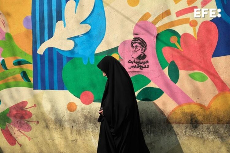 Un mujer camina frente a un grafiti del asesinado líder supremo de Irán Alí Jameneí en las inmediaciones de la plaza la plaza Engelab (Revolución) de Teherán. EFE/Jaime León