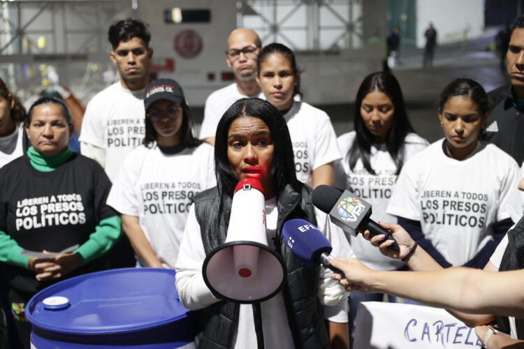 La familiar del detenido José Gregorio Farfán, Narwin Gil (c), habla durante una rueda de prensa este viernes, frente al centro penitenciario de la Policía Nacional Bolivariana (PNB) conocido como zona 7 en Caracas (Venezuela). EFE/ Ronald Pena R