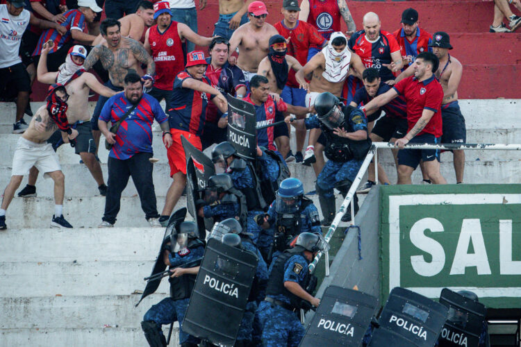 Hinchas de Cerro Porteño se enfrentan con la Policía de Paraguay durante el juego ante Olimpia, en el estadio Defensores del Chaco, en Asunción (Paraguay). EFE/ Derlis Martínez /SOLO USO EDITORIAL/ NO VENTAS/ SOLO DISPONIBLE PARA ILUSTRAR LA NOTICIA QUE ACOMPAÑA (CRÉDITO OBLIGATORIO)